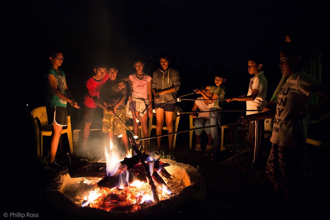 Kids enjoying roasting marshmallows over the campfire on our Kids Nature Camp