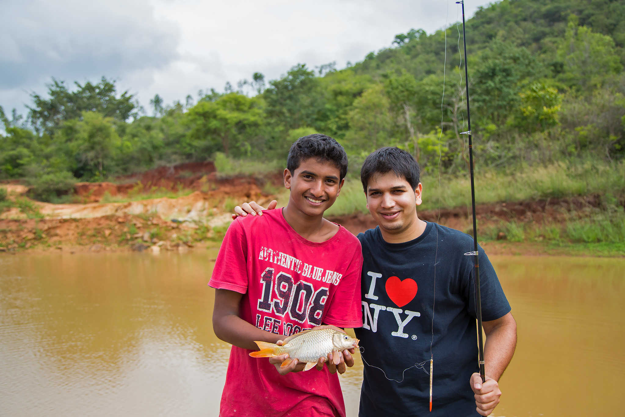 Two guests holding up a catch-and-release fish caught while angling at The Outback Farm and Homestay, as pictured on The Outback Experience's original site