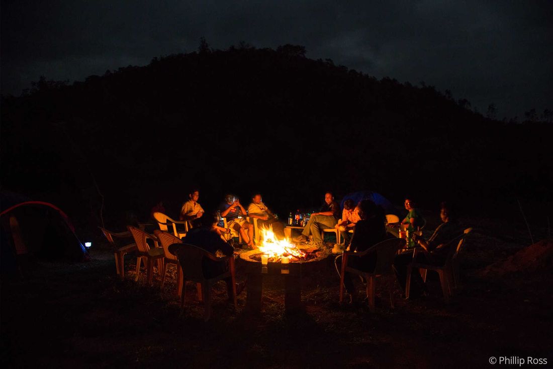 Guests sitting around a bonfire in the evening at The Outback Farm and Homestay