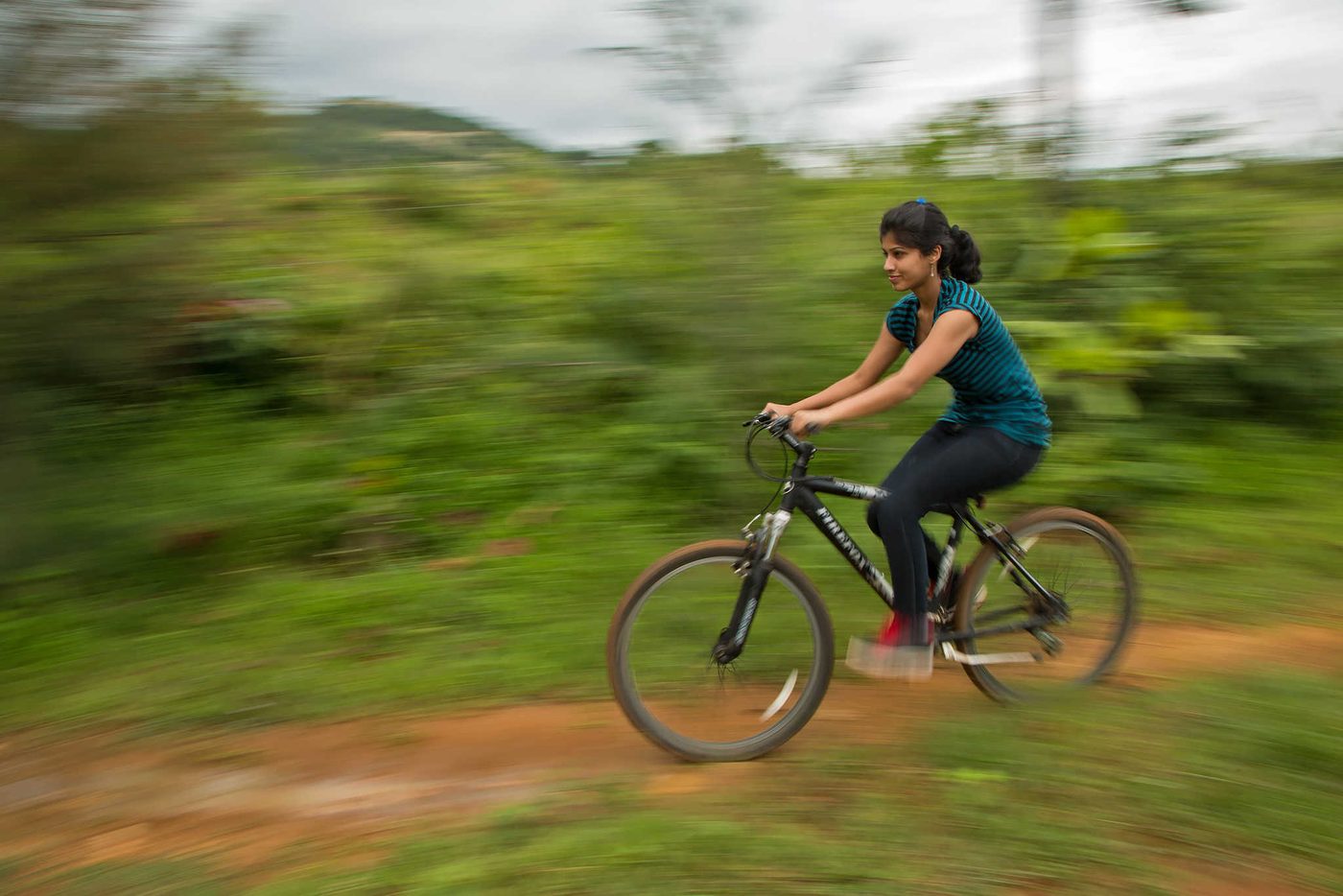 A cyclist on a trail at The Outback Farm, panned so the background blurs